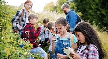 students sitting in the grass during a field trip